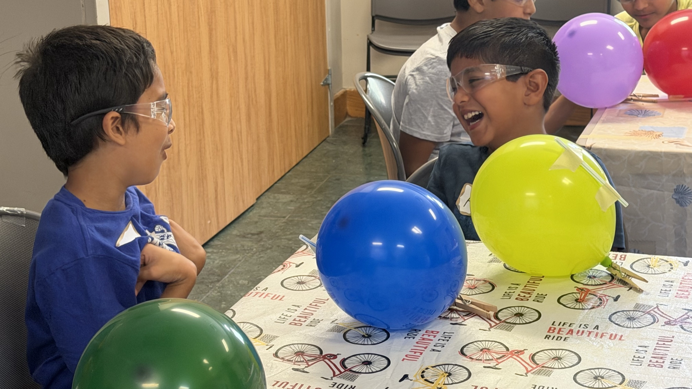 Students laughing together during a colorful balloon experiment